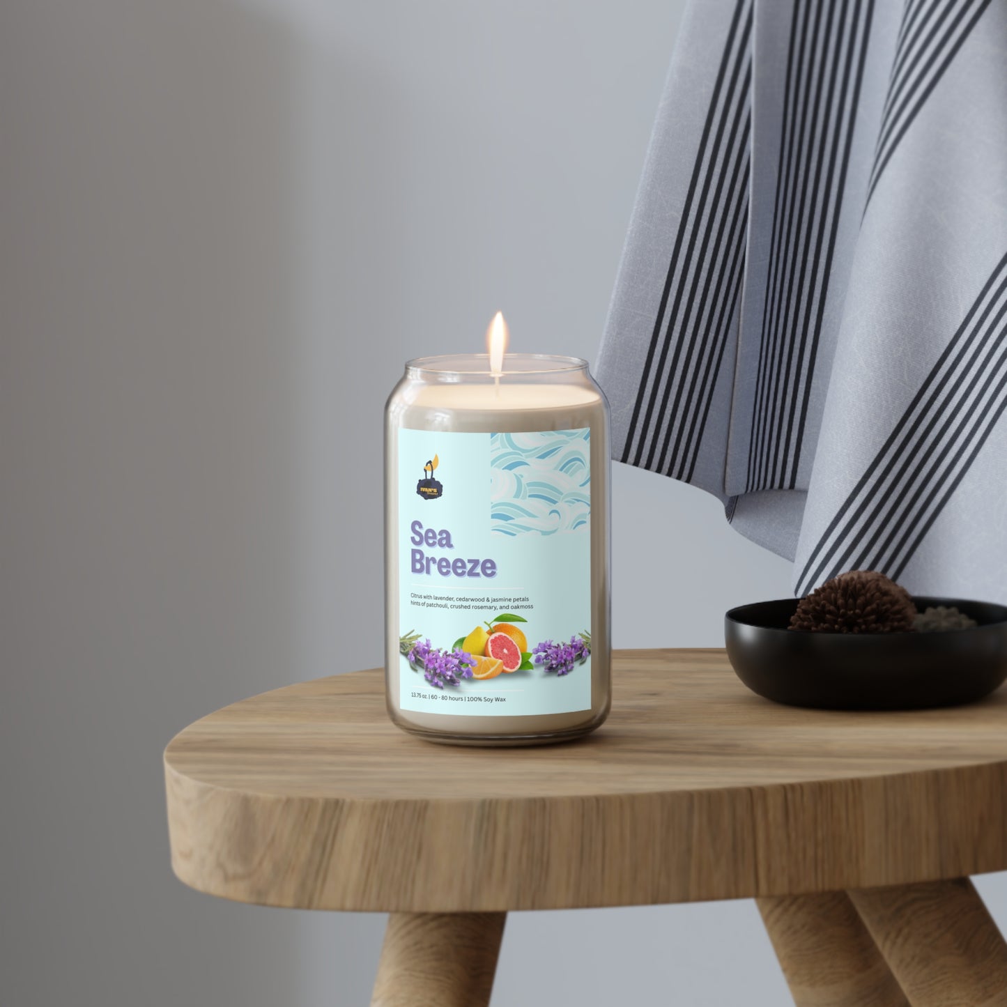 Candle labeled 'Sea Breeze' on a wooden table with a neutral background