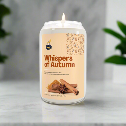 Candle labeled 'Whispers of Autumn' with a cinnamon stick and anise star on a neutral background